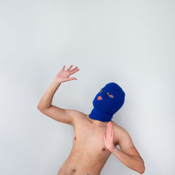 Portrait of man wearing balaclava against white background