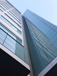 Low angle view of modern glass building against clear sky