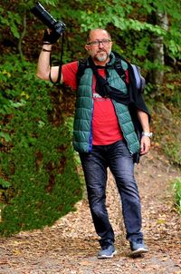 Full length of man photographing in forest