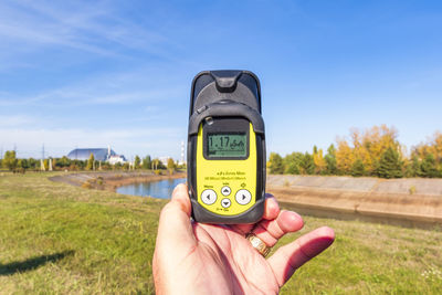 Ukraine, kyiv oblast, chernobyl, hand of man using geiger counter to measure radiation levels near chernobyl nuclear power plant