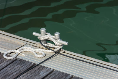 Close-up of rope tied to metal on pier