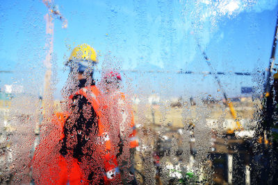 Close-up of wet glass window against clear sky