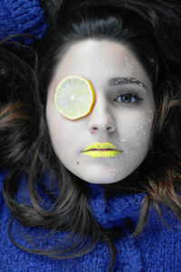 Portrait of young woman with lemon and yellow lipstick on face