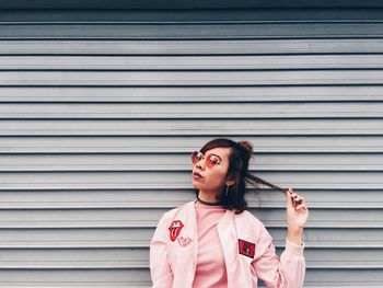 Young woman standing against wall