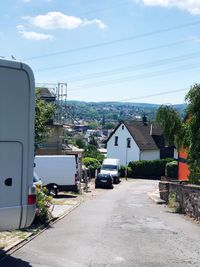 Road amidst buildings in city against sky