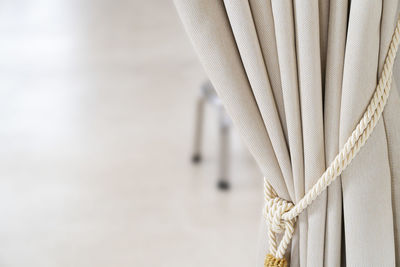 Close-up of rope tied on curtain at home