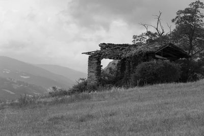 Abandoned built structure on field against sky