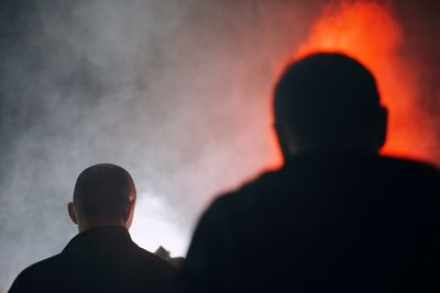 Rear view of people against sky at night