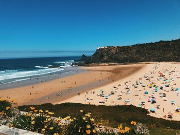 Scenic view of beach against clear blue sky