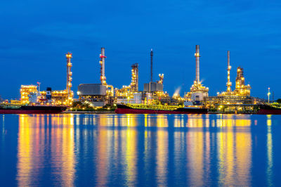 Illuminated factory against sky at night