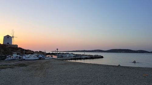 Scenic view of beach against clear sky during sunset