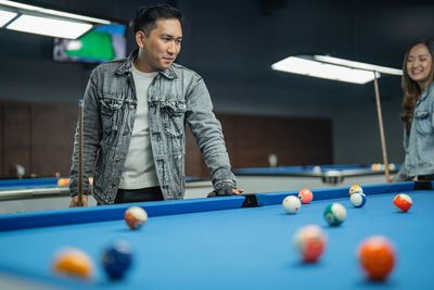 Midsection of man playing pool