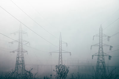 Low angle view of electricity pylon against sky