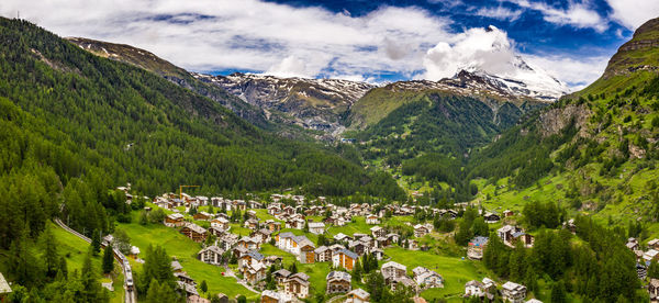 Panoramic view of townscape and mountains against sky