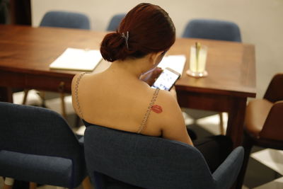 Rear view of woman using mobile phone