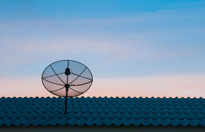 Low angle view of telephone pole against sky during sunset