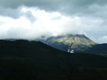 Scenic view of mountains against cloudy sky