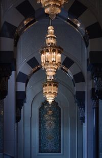 Low angle view of illuminated chandeliers of sultan qaboos mosque