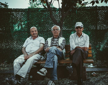 Men sitting on bench in park