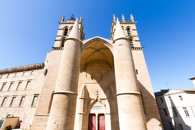 Low angle view of historic building against blue sky