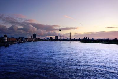 City by sea against sky during sunset