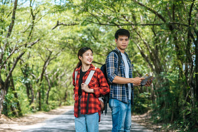 Young couple standing on land in forest