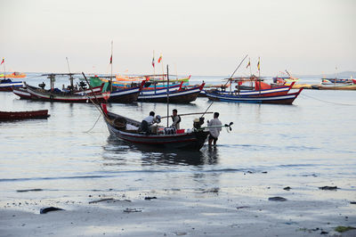 Boats moored in sea against clear sky