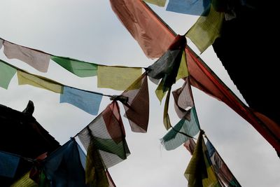 Low angle view of flags hanging against sky