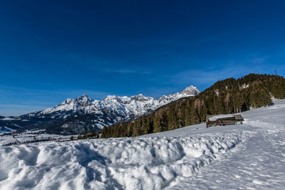 Scenic view of snowcapped mountains against blue sky