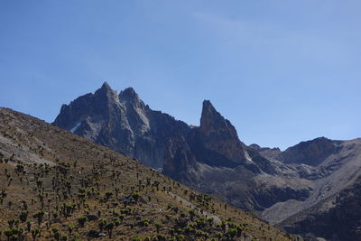 Low angle view of mountain against blue sky