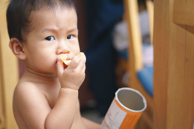 Portrait of cute boy eating chips at home