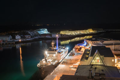 High angle view of illuminated bridge over river in city at night
