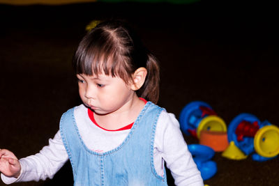 Cute girl with toys in darkroom