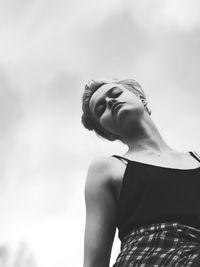 Low angle view of woman standing against sky