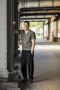 Portrait of young man standing against wall