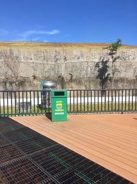 Information sign on fence against blue sky