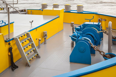 Yellow and blue painted    marine devices plus anchor chains at tidy nose of steel river barge