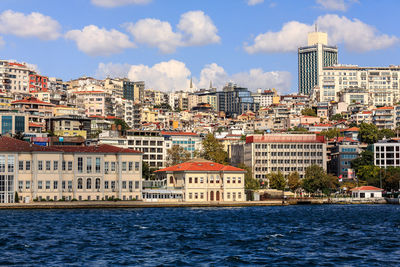 River and houses against sky in city