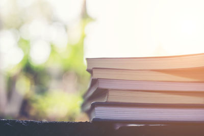 Close-up of stacked books on table outdoors