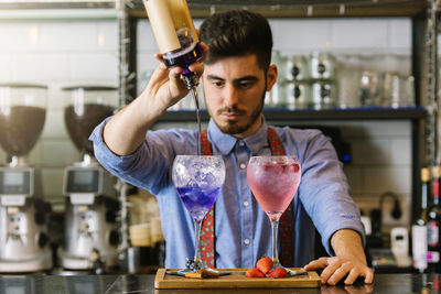 Male bartender preparing drinks at bar counter