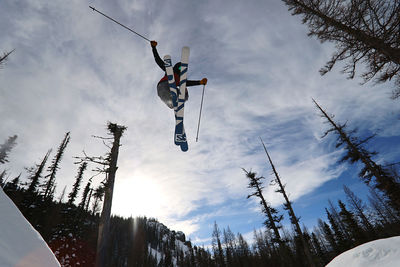 Low angle view of person paragliding against sky