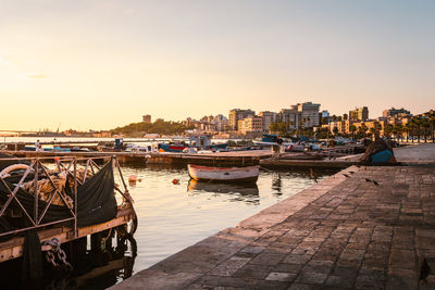 Boats moored at harbor against sky during sunset