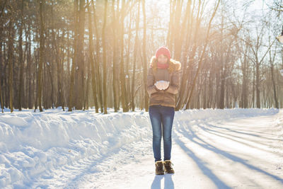 Woman walking on snow covered land