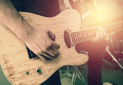 Midsection of man playing guitar