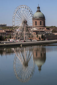 Reflection of ferris wheel in water