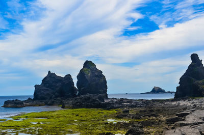 Rocks on beach against sky