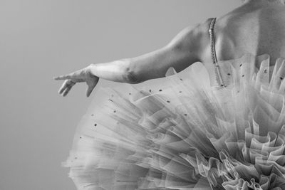 Midsection of ballet dancer against black background