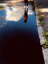 Low section of man standing on puddle