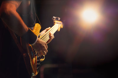 Midsection of man playing guitar