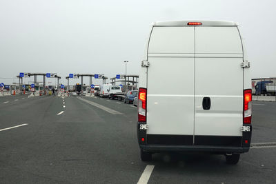 Vehicles on road against clear sky